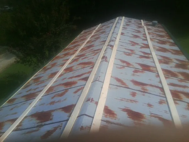 Rusted metal roof panels with new wood purlins before replacement — Storm Damage Roof Repair in Ashley Falls by Roofing Brothers