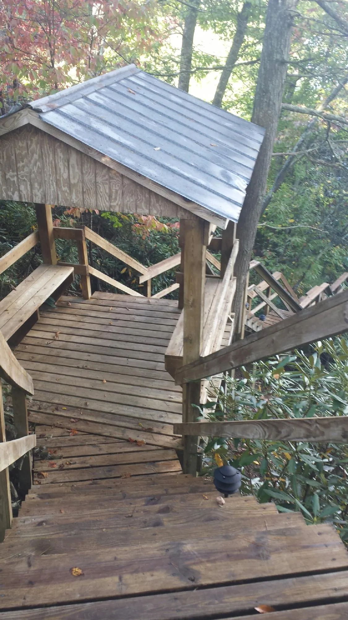 Metal roofed shelter over wooden steps on a wooded walkway — Skylight Repair & Installation work by our crew in Ashley Falls
