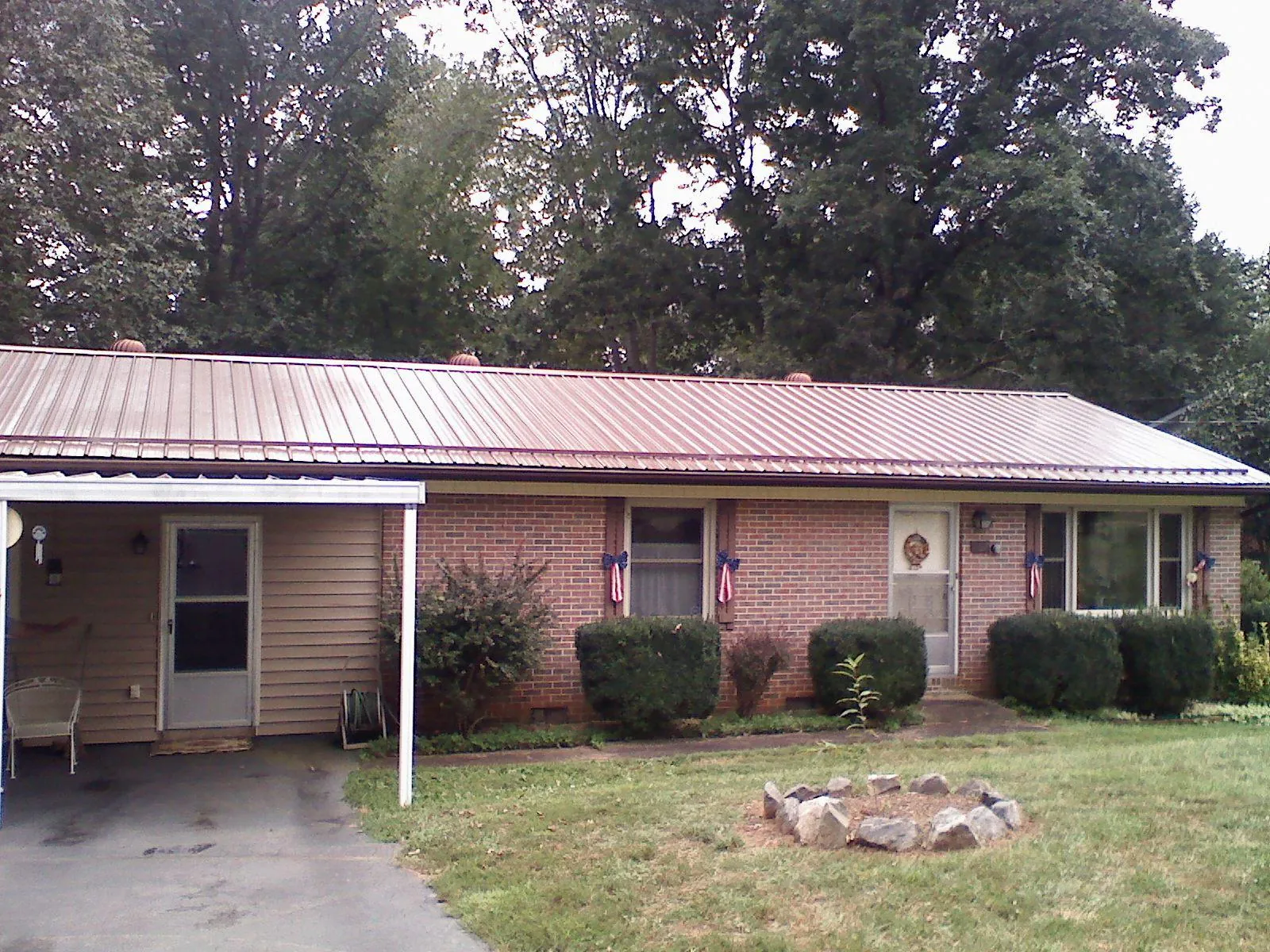 Bronze metal roof and carport on a brick ranch home — Roof Repair work by our crew in Ashley Falls